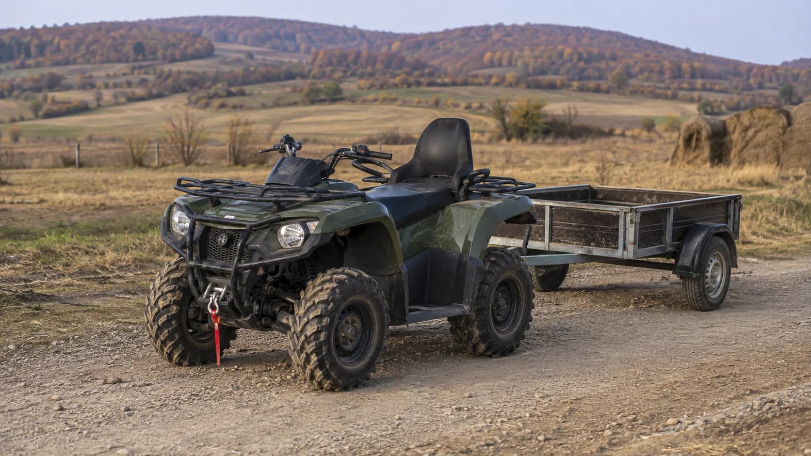 ATV utilitar cu remorcă mică pe un drum de exploatare agricolă