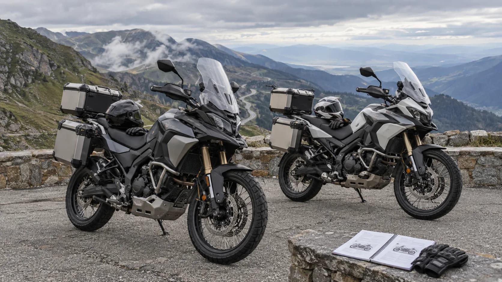 Două motociclete adventure touring cu bagaje parcate pe un drum montan