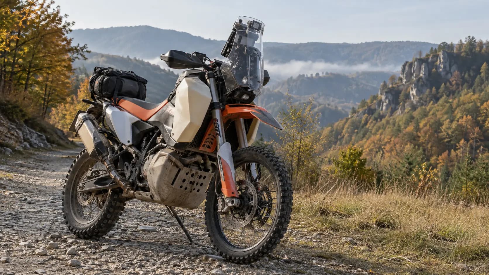Motocicletă rally adventure pe drum pietruit de munte toamna