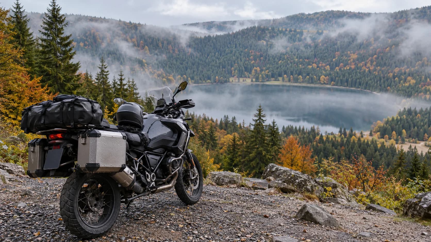 motocicletă touring lângă pădure și lac montan cu ceață de toamnă