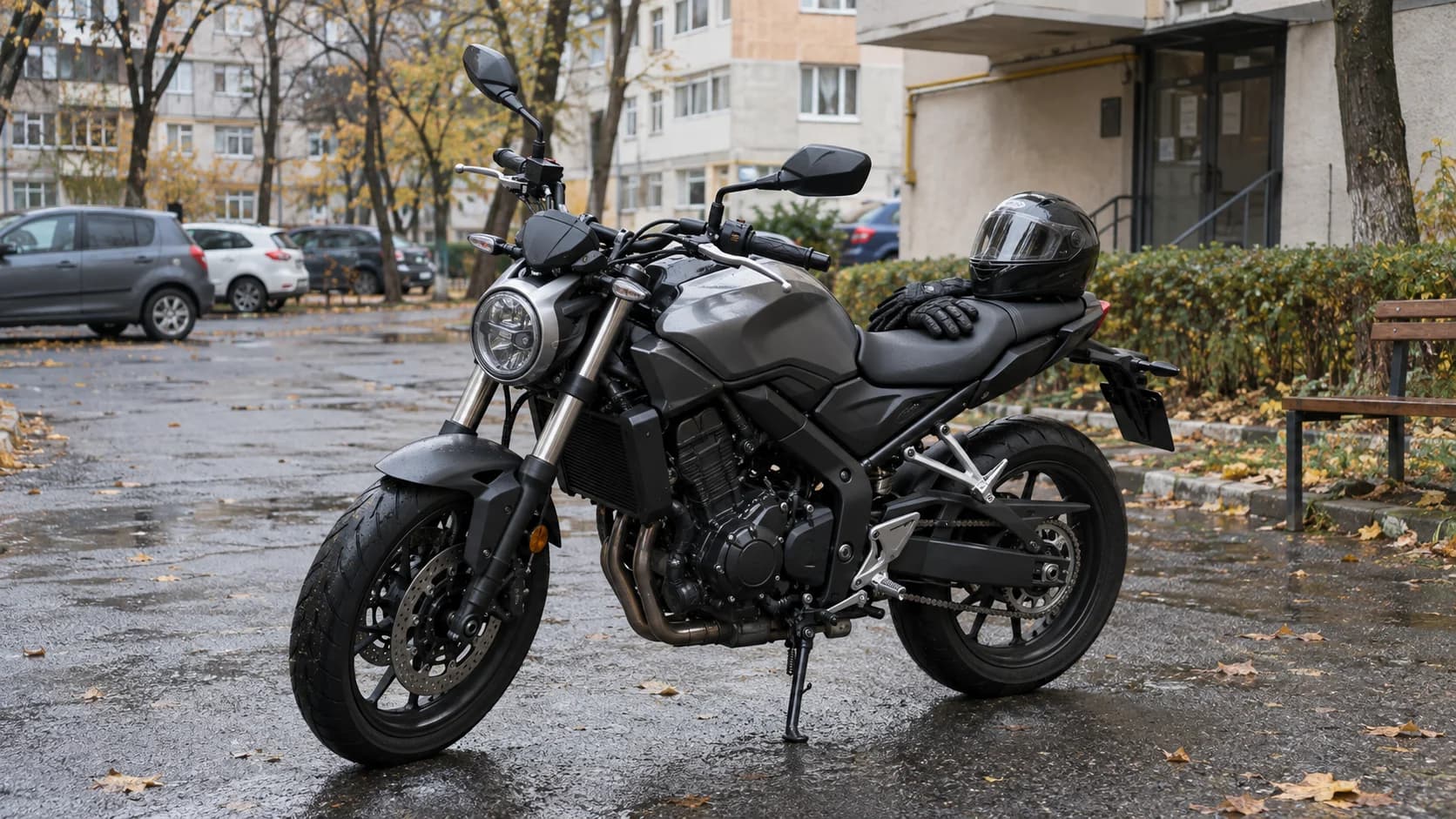 motocicletă naked ușoară parcată într-o curte de bloc după ploaie