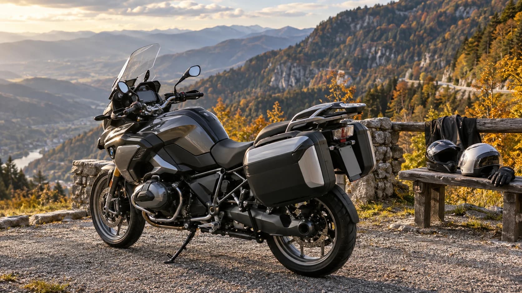 Motocicletă touring cu bagaje și două căști la un punct de belvedere montan