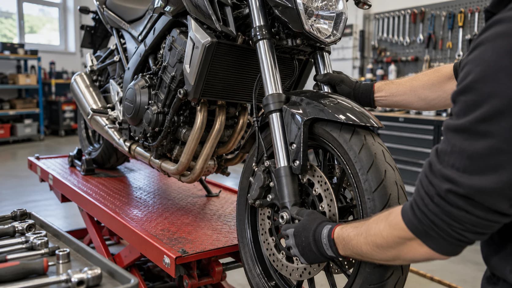 mecanic verifică partea frontală a unei motociclete pe elevator