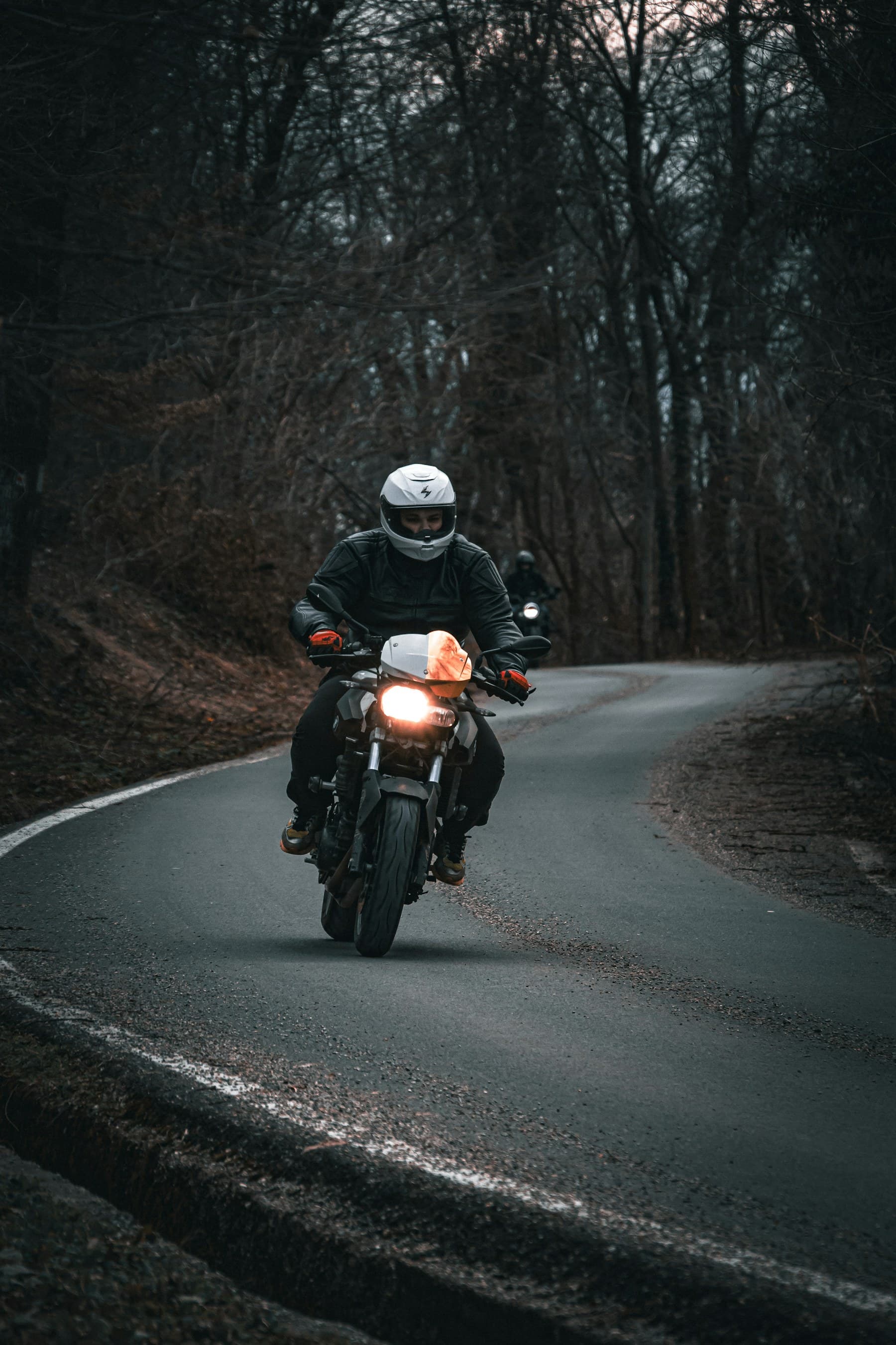 Motociclist pe un drum împădurit potrivit pentru o tură de weekend